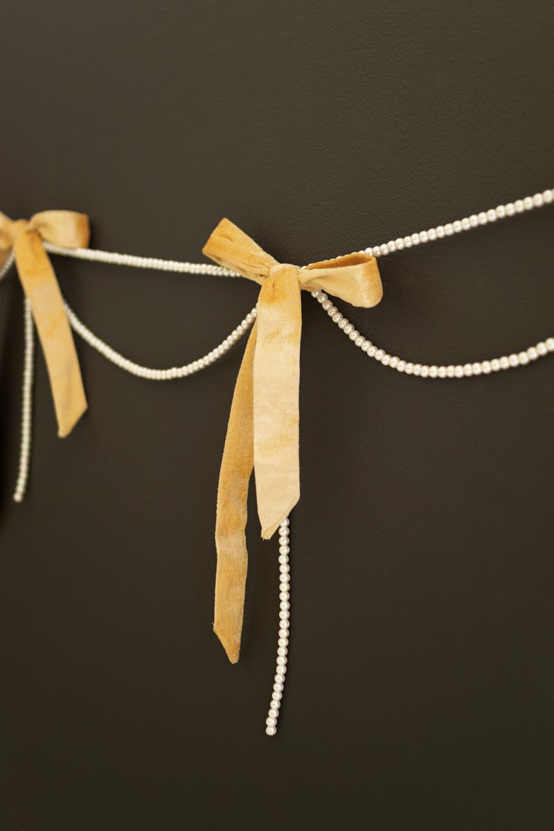 Gold Velvet Bow Garland with Faux Pearl Swag, A garland of velvet bows joined by gold rings with strands of faux pearls hanging between them.