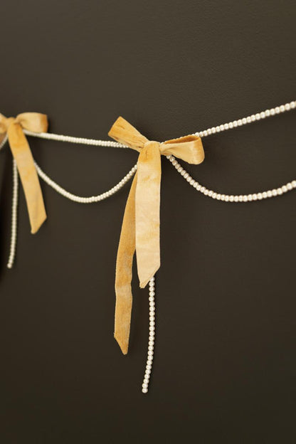 Gold Velvet Bow Garland with Faux Pearl Swag, A garland of velvet bows joined by gold rings with strands of faux pearls hanging between them.