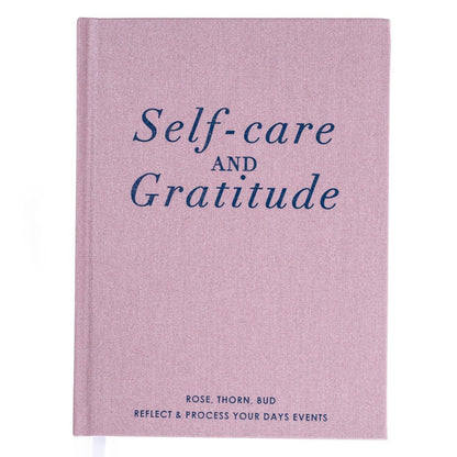 Gratitude Self-Care Journal, A dusty mauve fabric journal with 'Self-care and Gratitude' in navy foil above a rose, thorn, bud reflection format.