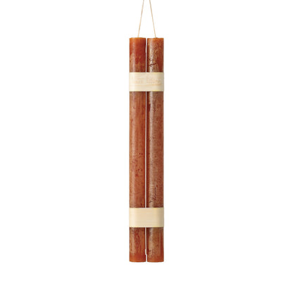 Hanging Timber Taper Candles 12 Inch, Pair, Two amber colored taper candles bound together with cream paper bands hang side by side against a plain white background.