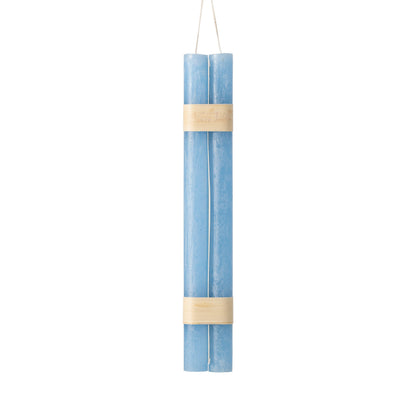 Hanging Timber Taper Candles 12 Inch, Pair, Two amber colored taper candles bound together with cream paper bands hang side by side against a plain white background.