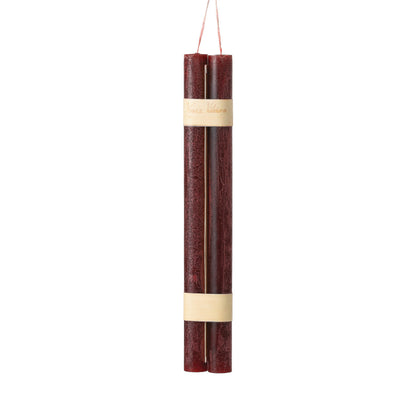 Hanging Timber Taper Candles 12 Inch, Pair, Two amber colored taper candles bound together with cream paper bands hang side by side against a plain white background.