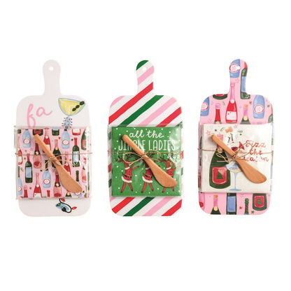 Holiday Bar Melamine Board with Napkins and Spreader, Three holiday melamine paddle boards, each with a wrapped pack of cocktail napkins and a wooden spreader tied on.