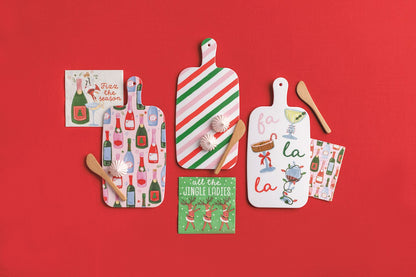 Holiday Bar Melamine Board with Napkins and Spreader, Three holiday melamine paddle boards, each with a wrapped pack of cocktail napkins and a wooden spreader tied on.