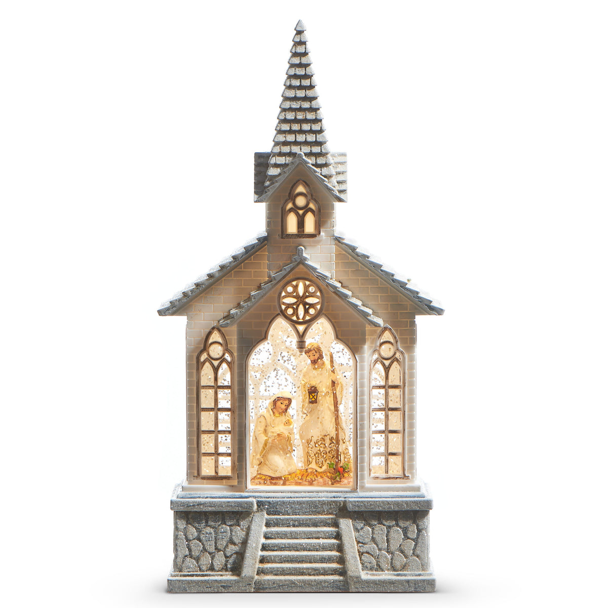 Holy Family Musical Lighted Water Church, A white church with a snow dusted shingled steeple and gray stone steps, its center arched window lit to show the Holy Family behind swirling glitter.