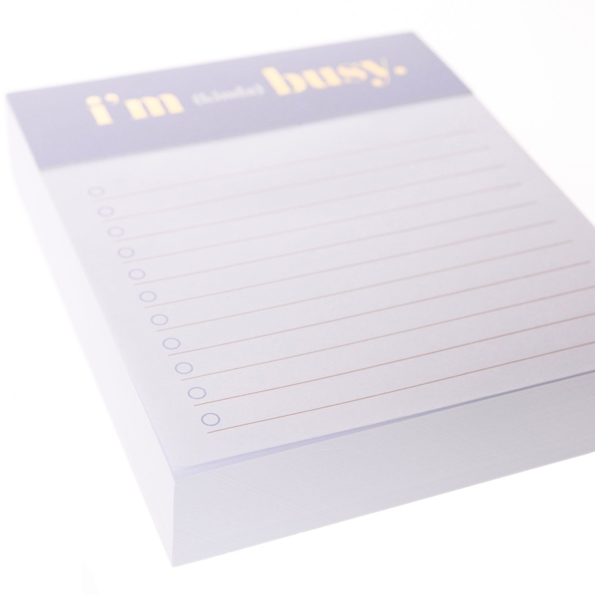 I'm Busy Jotter Notepad, A lavender-topped jotter notepad printed with 'i'm (kinda) busy' in gold foil above lined, checkbox-style pages.