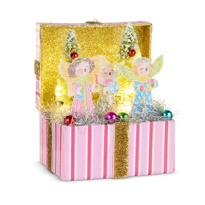Lighted Choir Angel Vignette Box, An open pink and white striped box with a gold glitter lid, holding three paper angels, two small bottle brush trees, silver tinsel and colored baubles lit from inside.