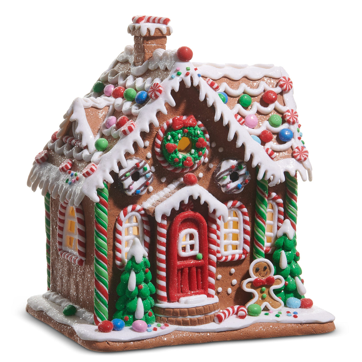 Lighted Gingerbread House with Timer, A lighted clay dough gingerbread house with a chimney, white icing drips, a candy-studded roof, a wreath above a red front door, glowing windows, two small trees and a gingerbread man by the steps.