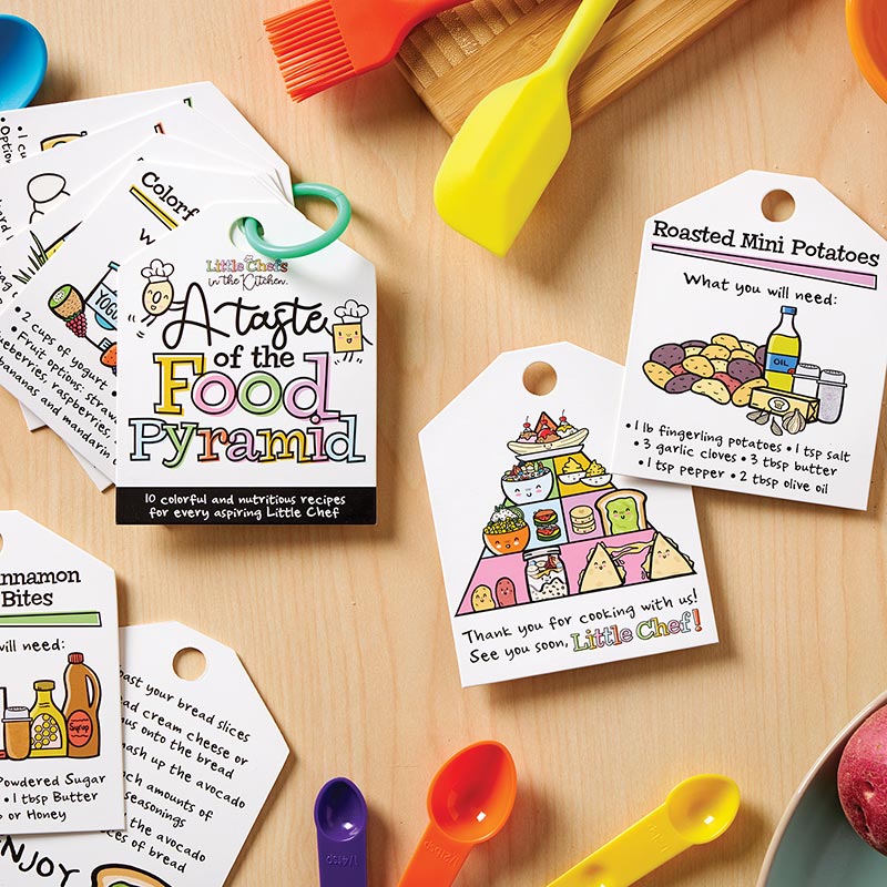 Little Chefs in the Kitchen Food Pyramid Recipe Cards, Recipe cards fanned out on a teal ring, the front card reading A Taste of the Food Pyramid with two chef-hatted food characters and the line 10 colorful and nutritious recipes for every aspiring Little Chef.