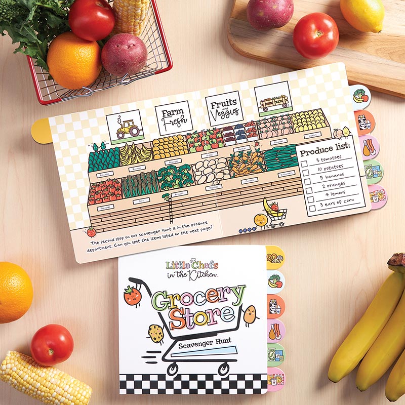 Little Chefs in the Kitchen Grocery Store Scavenger Hunt Board Book, The cover of the Grocery Store Scavenger Hunt board book, showing a shopping cart with three smiling food characters above a black and white checkered band, with six food-picture tabs down the right edge.