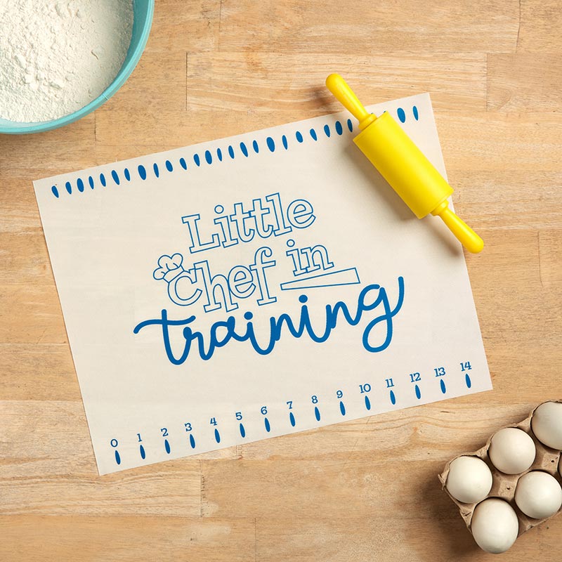 Little Chefs in the Kitchen Rolling Pin with Baking Mat, A clear gift box holding a yellow rolling pin and a folded baking mat, with a Little Chefs in the Kitchen label on a sprinkle-dot backing card.
