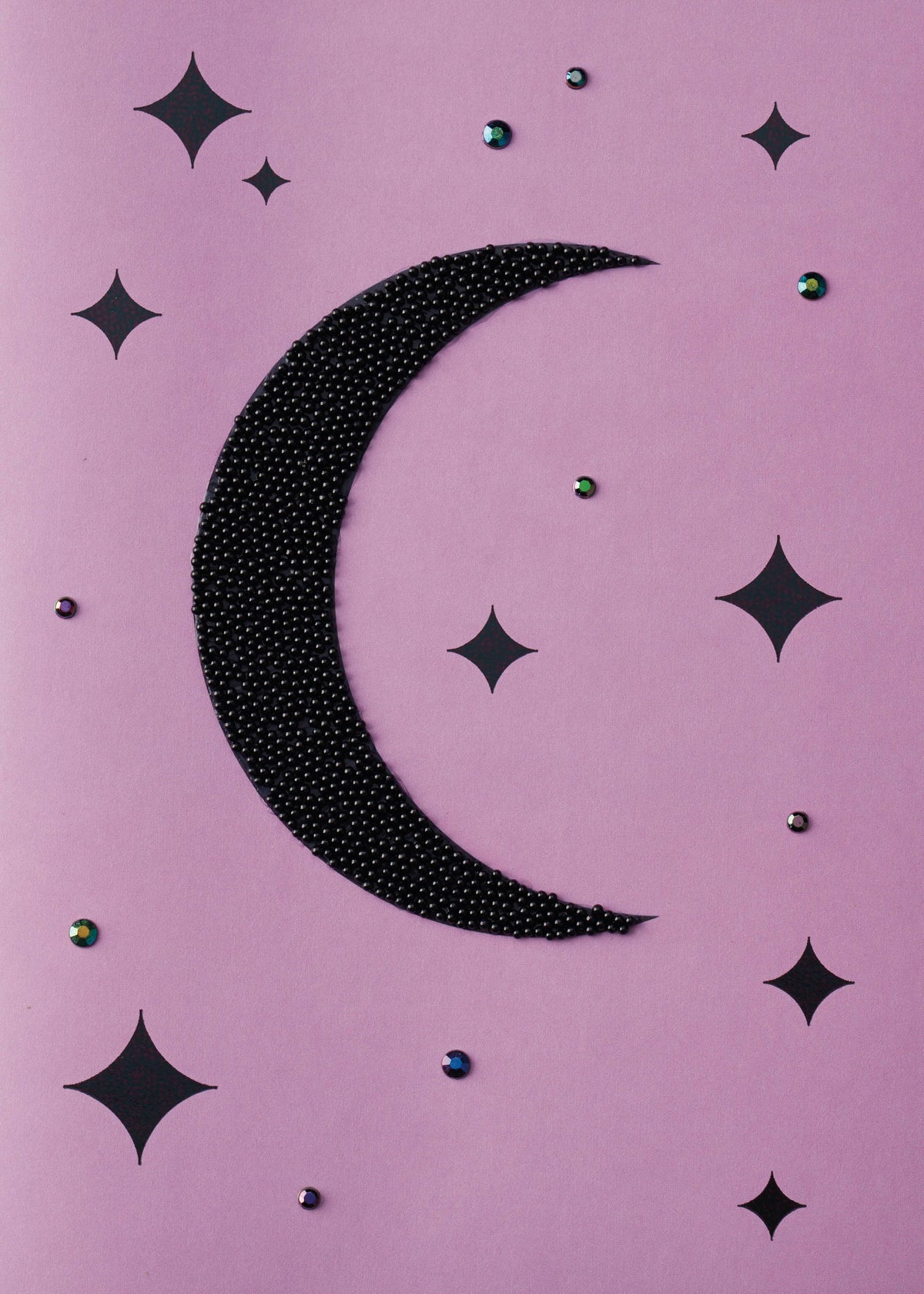 Magical Starry Night Greeting Card, Front of the card showing a crescent moon covered in tiny black beads among black four-point stars and small iridescent gems on a lilac ground.