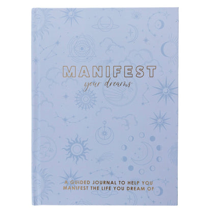 Manifest Self-Care Journal, A periwinkle blue fabric journal printed with celestial suns, moons, and stars under 'Manifest Your Dreams' in gold foil.