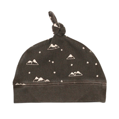 Organic Cozy Top-Knot Hat, Bark Mountains Print, A dark brown knit baby hat with a top knot tie and a cream mountains and stars print.