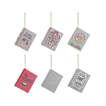 MDF and Canvas Book Ornament, Six miniature book ornaments made of reclaimed wood and canvas, each cover lettered with a different holiday greeting: Seasons Greetings, Merrily Ever After, Tidings of Comfort and Joy, Tis the Seasoning, Thrill of Hope, and Joy to the World.