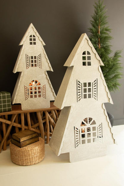 Metal Christmas Village Lamp, Two illuminated metal Christmas village house lamps, one large and one small, glowing from inside.