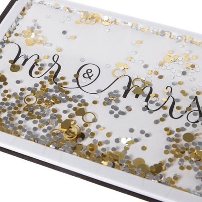 Mr. and Mrs. Wedding Handmade Card, A white card reading mr & mrs in black script behind a gold and silver confetti shaker with gold ring shapes, shown with its envelope.