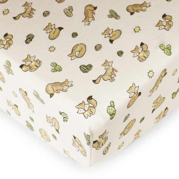 Organic Crib Sheet, Little Fox Print, A cream fitted crib sheet printed with small illustrated foxes, cacti, and sun motifs, shown stretched over a mattress corner.