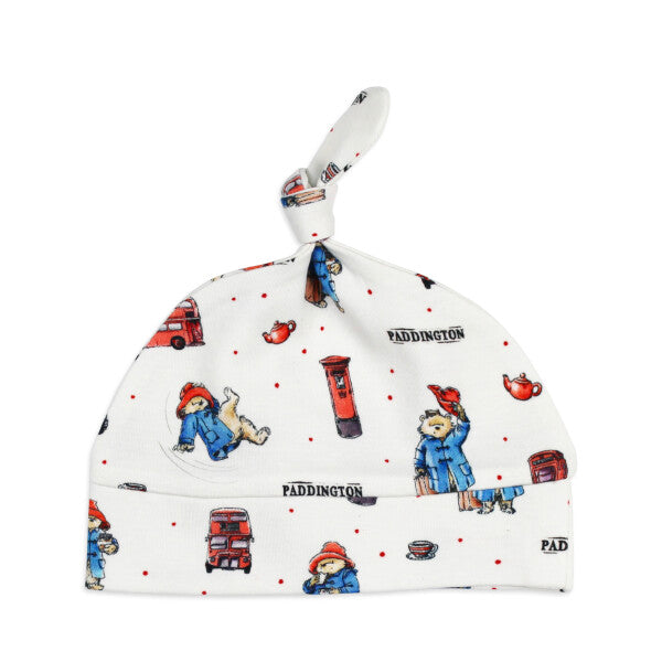 Organic Knotted Baby Hat, London Paddington Print, A white knotted baby hat printed with London themed illustrations of Paddington Bear, red buses, post boxes, and teacups.