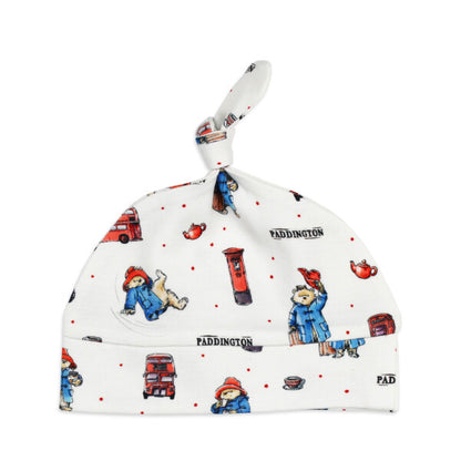 Organic Knotted Baby Hat, London Paddington Print, A white knotted baby hat printed with London themed illustrations of Paddington Bear, red buses, post boxes, and teacups.