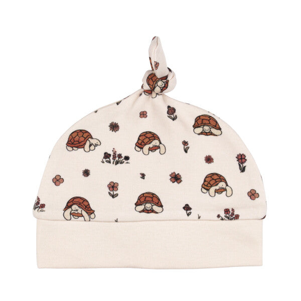 Organic Knotted Baby Hat, Tiny Tortoise Print, A cream colored knotted baby hat printed with small tortoises and flowers, with a ribbed cuff and knotted top.