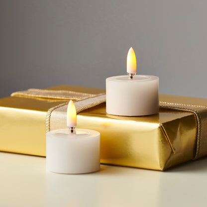 Pair of Ivory Melted Top Flameless Tealights, Two ivory flameless tealights with melted wax tops and lit flame-shaped tips, side by side on a white background.