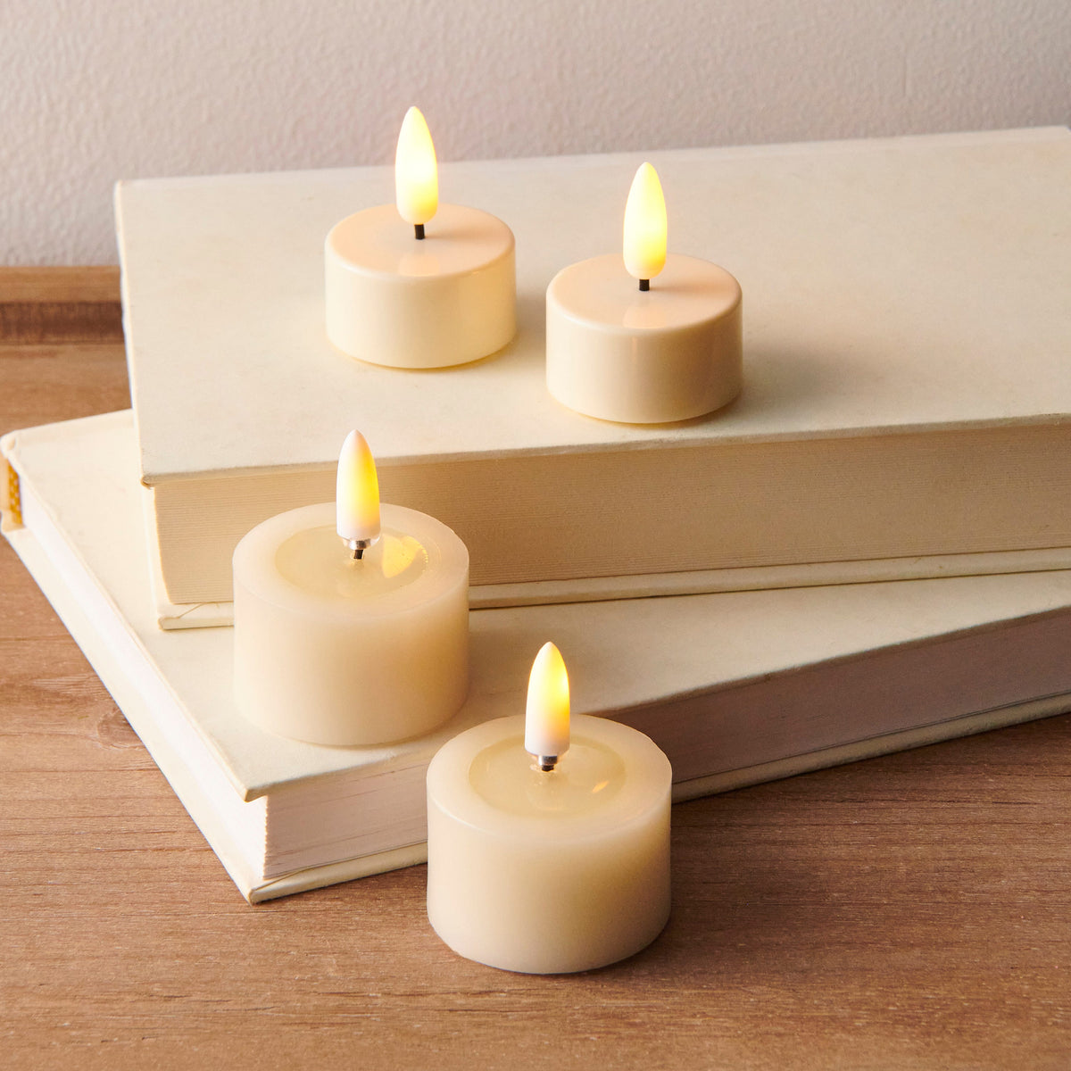 Pair of Ivory Melted Top Flameless Tealights, Two ivory flameless tealights with melted wax tops and lit flame-shaped tips, side by side on a white background.
