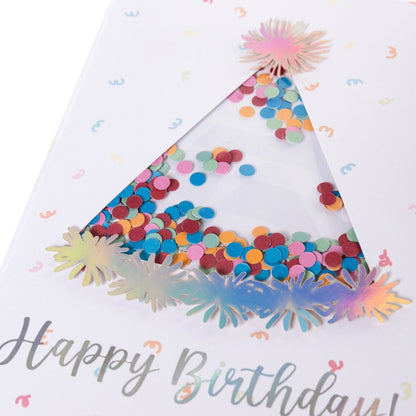 Party Hat Handmade Card, A white card with a die-cut party hat window filled with colorful confetti, silver holographic foil Happy Birthday text, and pom-pom tip-ons, shown with its envelope.