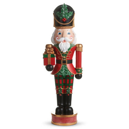 Plaid Nutcracker, A tall resin nutcracker soldier in red and green plaid, holding a wrapped gift and a baton.