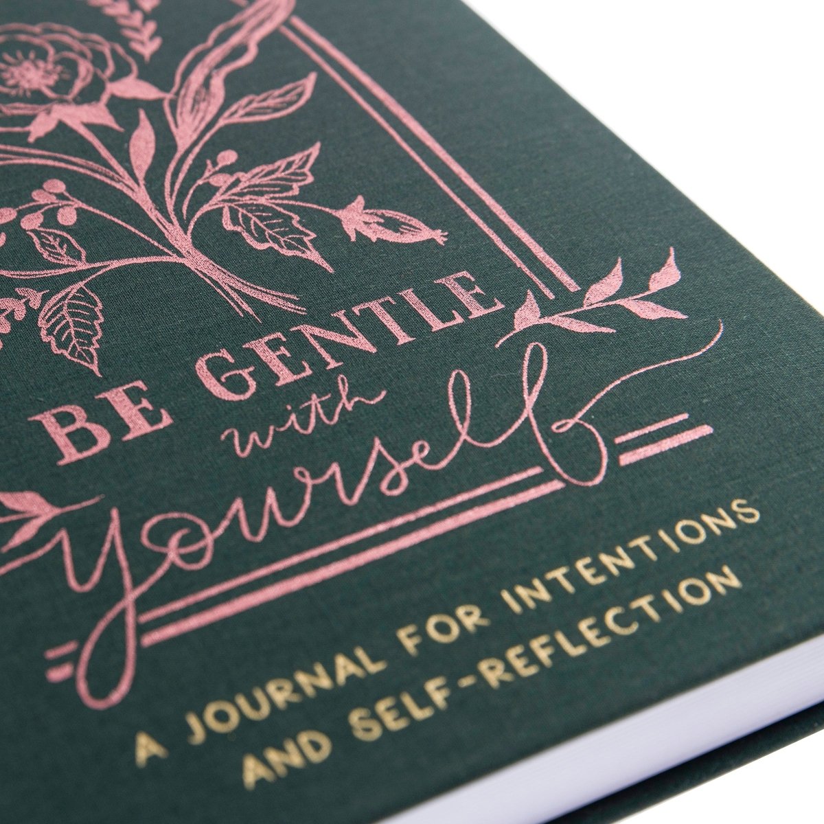 Positive Self-Care Journal, A deep green fabric journal with a rose gold botanical arch and 'Be Gentle With Yourself' foiled on the cover.