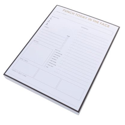 Punch Today Large Notepad, A black-bordered notepad printed 'Punch Today In The Face' in gold foil above sections for priorities, schedule, water, meals, and self-care.
