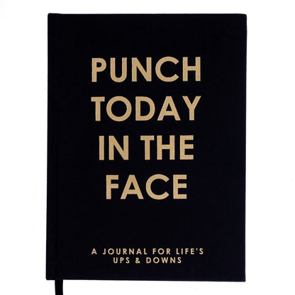 Punch Today Self-Care Journal, A black fabric journal with 'Punch Today In The Face' foiled in gold above 'a journal for life's ups and downs'.