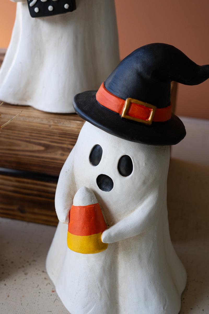 Resin Halloween Ghost, Two white resin ghost figures on a wooden crate, one wearing round orange glasses and holding a black BOO sign, the other wearing a black witch hat and holding a candy corn.