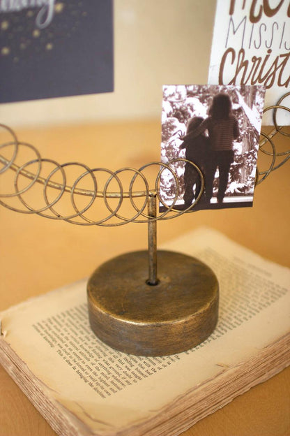 Round Wire Christmas Card Holder on a Stand, A round wire card holder on a stand with cards tucked into the wire.