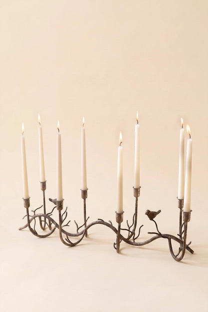 Rustic Metal Candelabra with Birds, A long curved iron candelabra with eight taper holders and two small bird figures.