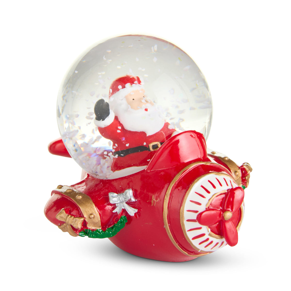 Santa Airplane Snow Globe, A small snow globe with Santa waving from the cockpit of a red airplane trimmed in gold, with a red propeller and a green garland on its side.