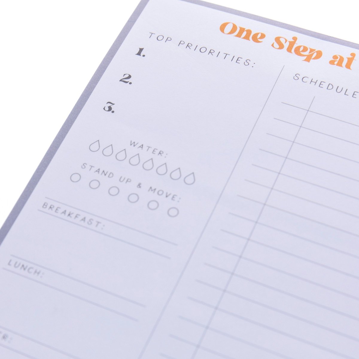 Self Care Large Notepad, A gray-bordered notepad printed 'One Step at a Time' in orange above sections for priorities, meals, water, movement, and self-care.