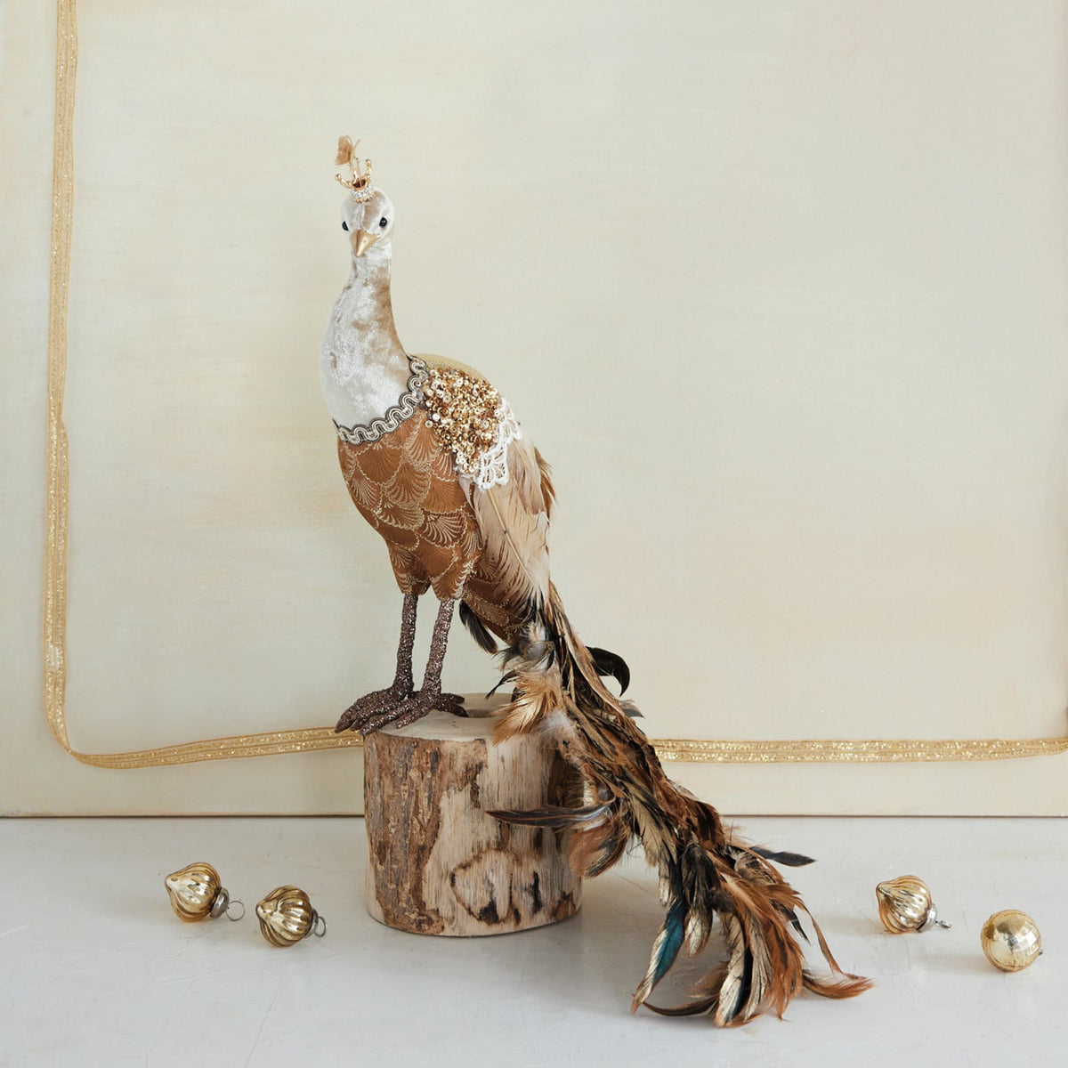 Sequin and Feather Peacock Figurine, Brown, A brown and gold peacock figurine with a long feathered tail trailing behind it and a small crown on its head, shown against a white background.