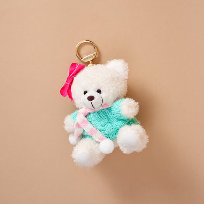 Teddy Bear Bag Charm, A golden brown plush teddy bear bag charm dressed in a black and white football jersey, holding a football, with a gold clasp.