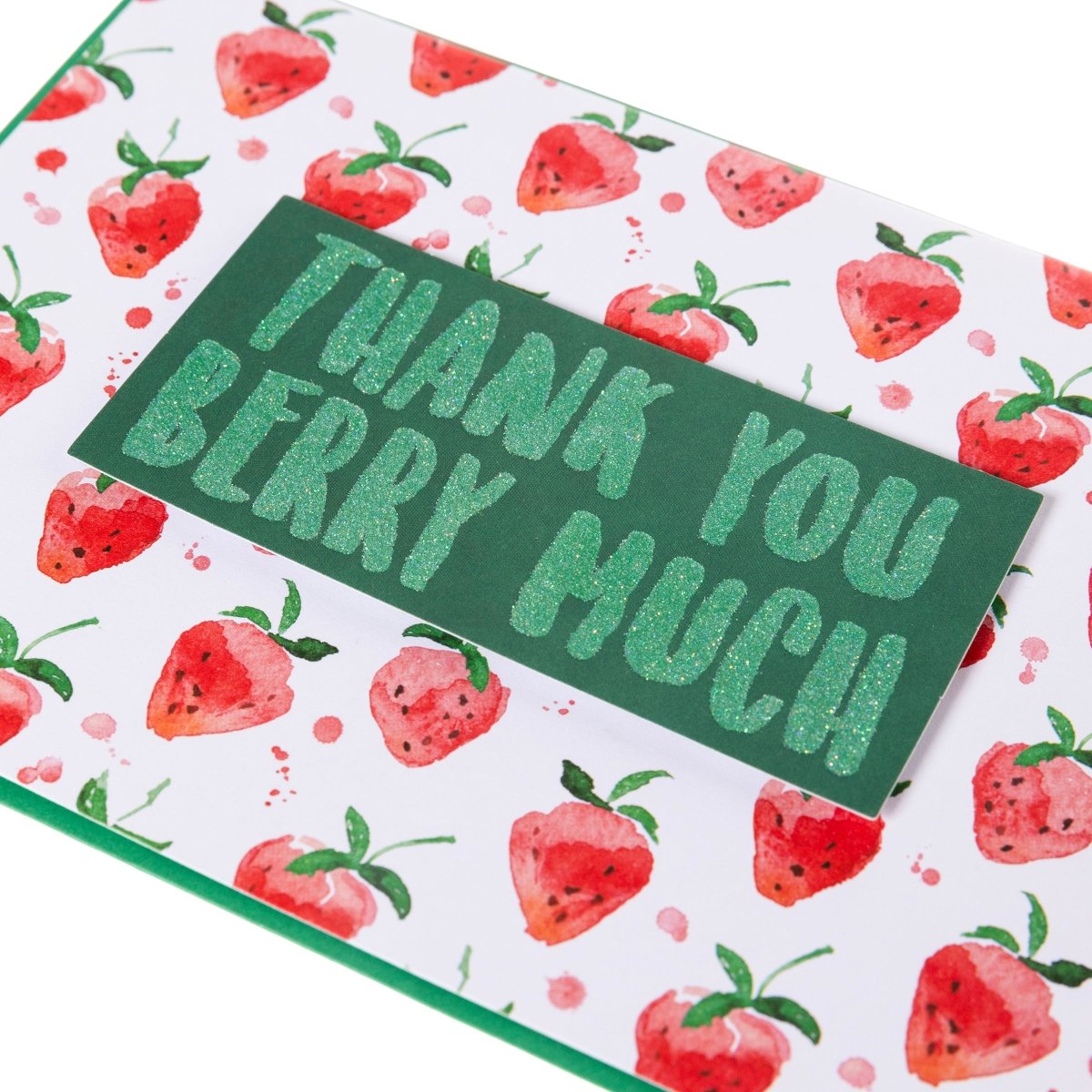 Thank You Berry Much Thank You Handmade Card, A white card patterned with watercolor strawberries and a green glitter tip-on banner reading Thank You Berry Much, shown with its envelope.