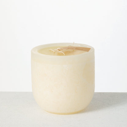 Timber Goblet Candle 6 x 6 Inch, A round, cup-shaped candle in golden amber wax with a mottled, bark-like surface, a wide cream wax top holding a looped wick, and a wooden tag reading Vance Kitira resting across the rim.