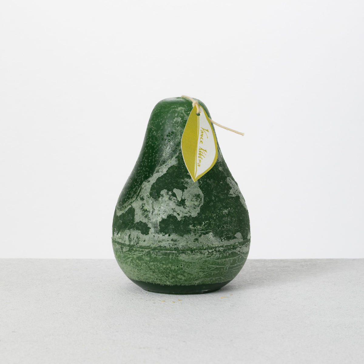 Timber Pear Candle 3 x 4 Inch, A green pear shaped candle with a textured surface stands tied with a small leaf shaped hang tag.