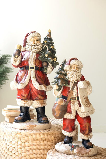 Traditional Faux Concrete Santa with Bell, A tall faux concrete Santa figure in a red suit holding a small Christmas tree.