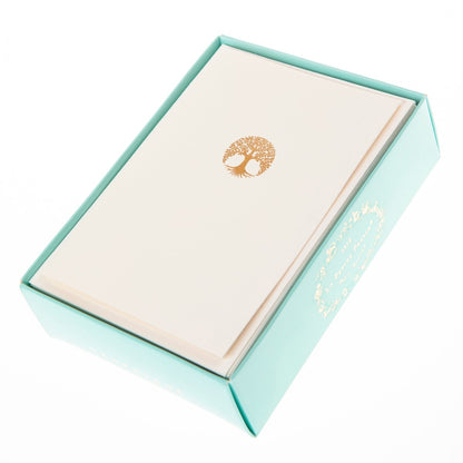La Petite Presse Tree Boxed Notes, A cream notecard with a gold foil tree of life icon, tied with a bronze ribbon inside a teal box.