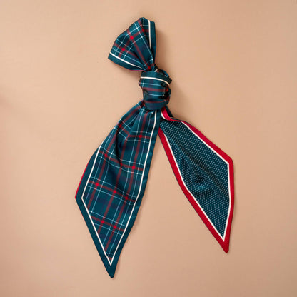 Twirl & Tie Scarf Accessory, A red and white gingham satin scarf tied in a knot, showing a red polka dot pattern on the reverse side of the tails.