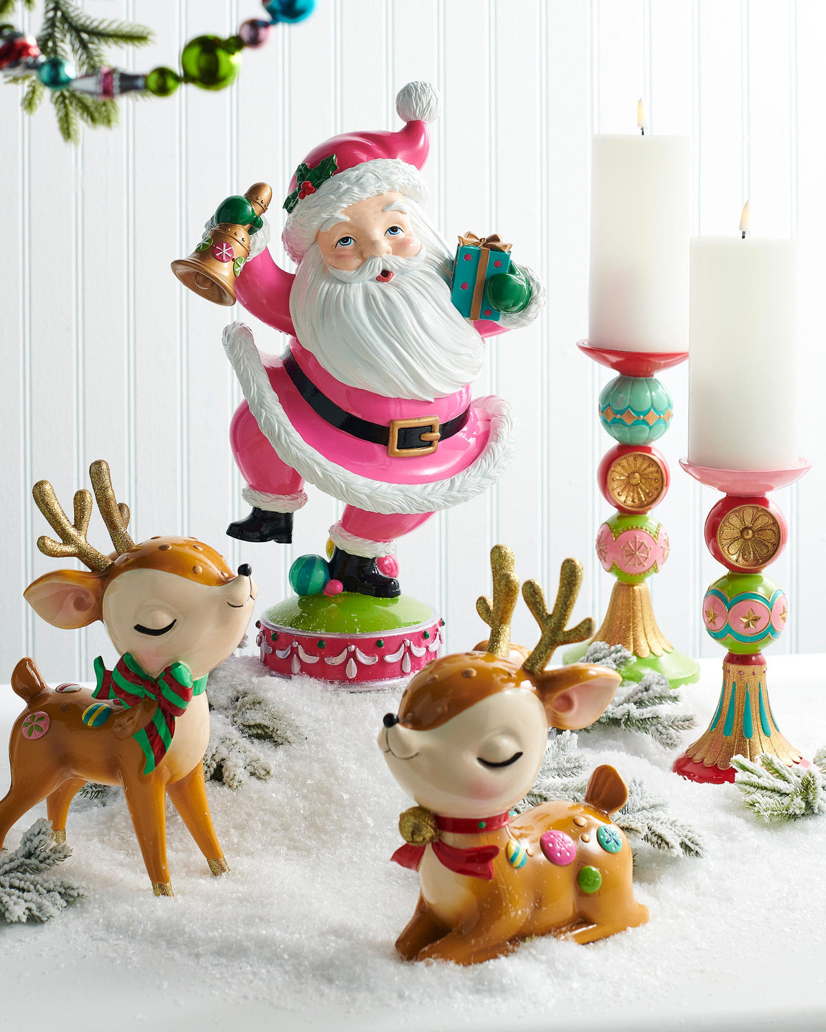 Whimsical Retro Reindeer Figurine with Glitter Antlers, Two retro resin reindeer with gold glitter antlers and closed, smiling eyes, one sitting with a red scarf and bell and one standing with a red and green striped bow.