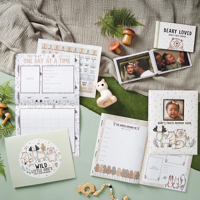 Woodland Adventure Baby Keepsake, The Woodland Adventure First Year Calendar cover is sage green with a white circle of a fox, a moose and a bear above the words Wild Little One's First Year Calendar.