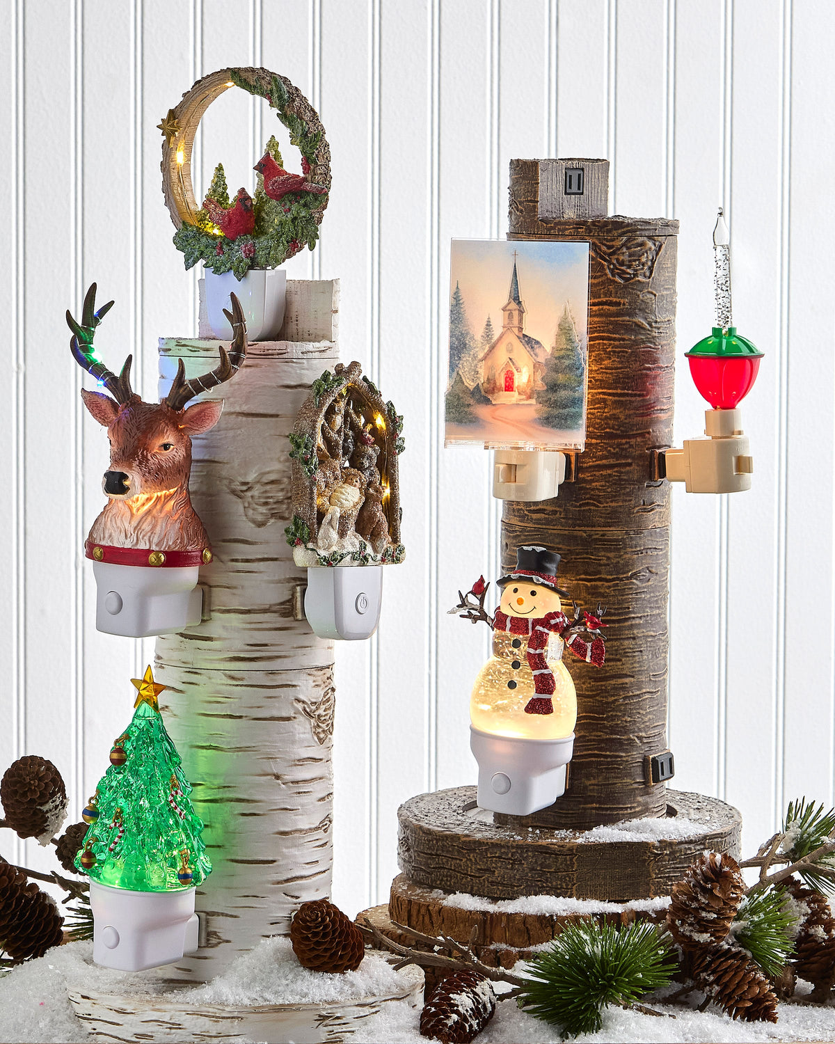 Swirling Glitter Snowman Night Light, A lit snowman night light with a clear glitter-filled body, black top hat, red striped scarf and red cardinals on twig arms, on a white plug-in base.